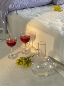 Deux verres de Bourgogne Claret accompagné de raisins et une carafe d'eau