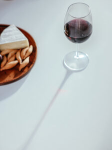 Verre de vin rouge Lalande de Pomerol accompagné de fromage et d'apéritifs